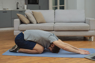 Young woman sitting on sofa at home