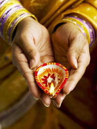 Midsection of woman holding diya