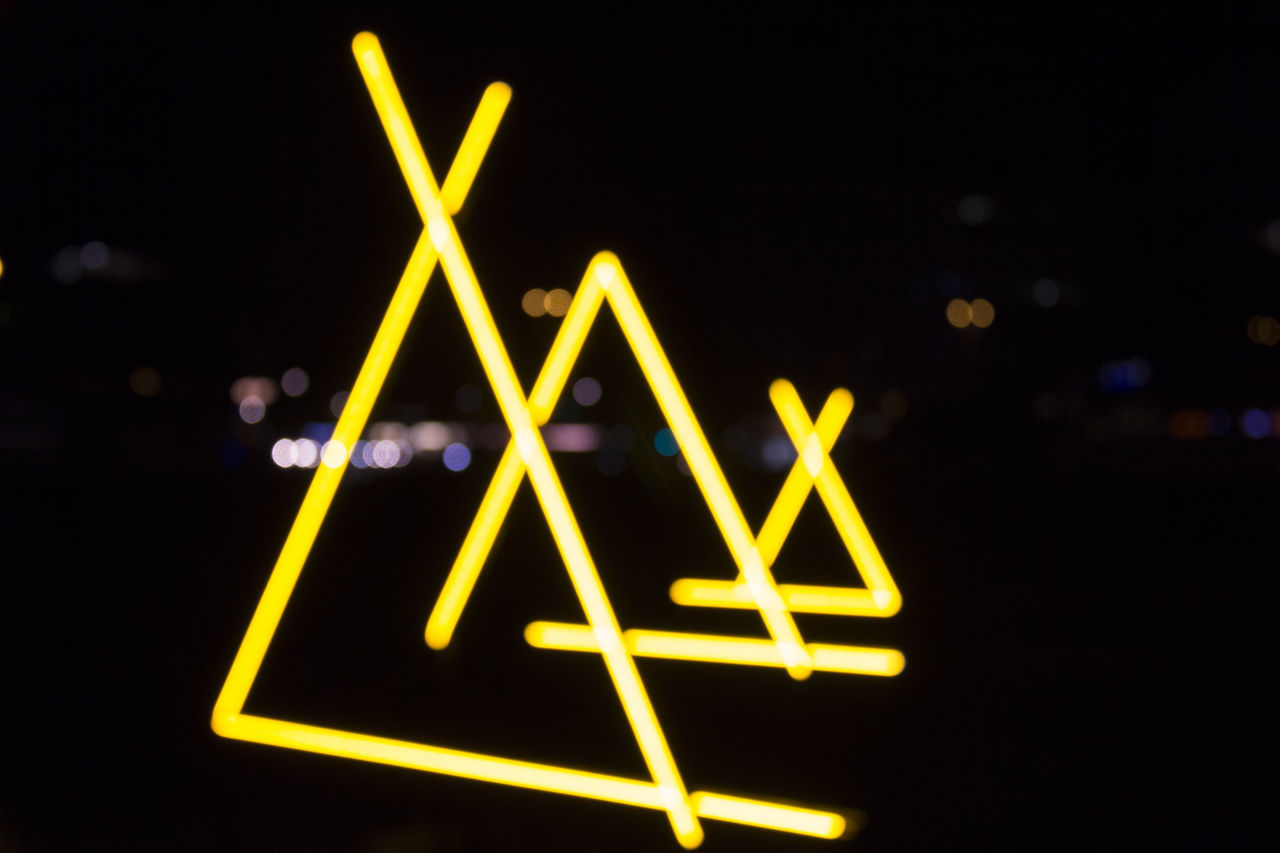 CLOSE-UP OF ILLUMINATED YELLOW SIGN ON WALL