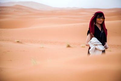 Young woman on sand dune in desert