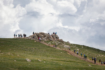 People on mountain against sky