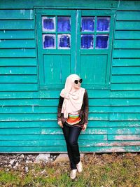 High angle view of woman standing against window of house