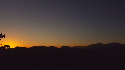 Scenic view of silhouette mountains against sky at sunset