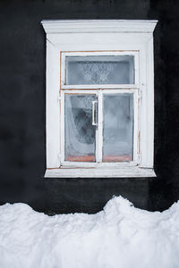 Snow covered window of house on field