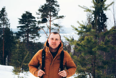 Portrait of man in snow against trees