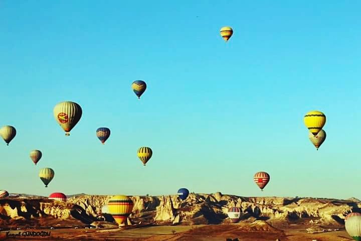 flying, mid-air, parachute, hot air balloon, low angle view, clear sky, paragliding, adventure, extreme sports, exhilaration, blue, transportation, parachuting, multi colored, copy space, fun, sky, leisure activity, sport, balloon