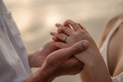 Midsection of couple holding hands