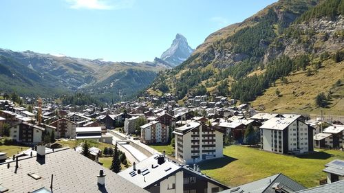 Townscape by mountains against sky