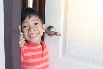 Portrait of smiling boy standing at home