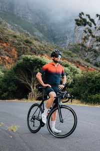 Rear view of man riding bicycle on road