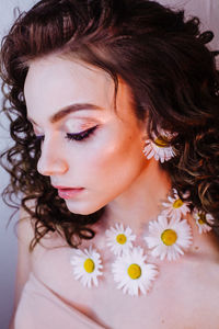 Close-up of beautiful young woman wearing flowers and make-up