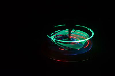 Close-up of illuminated lighting equipment against black background