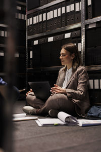 Rear view of woman using laptop on table