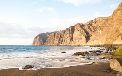 Scenic view of rocks on beach against sky