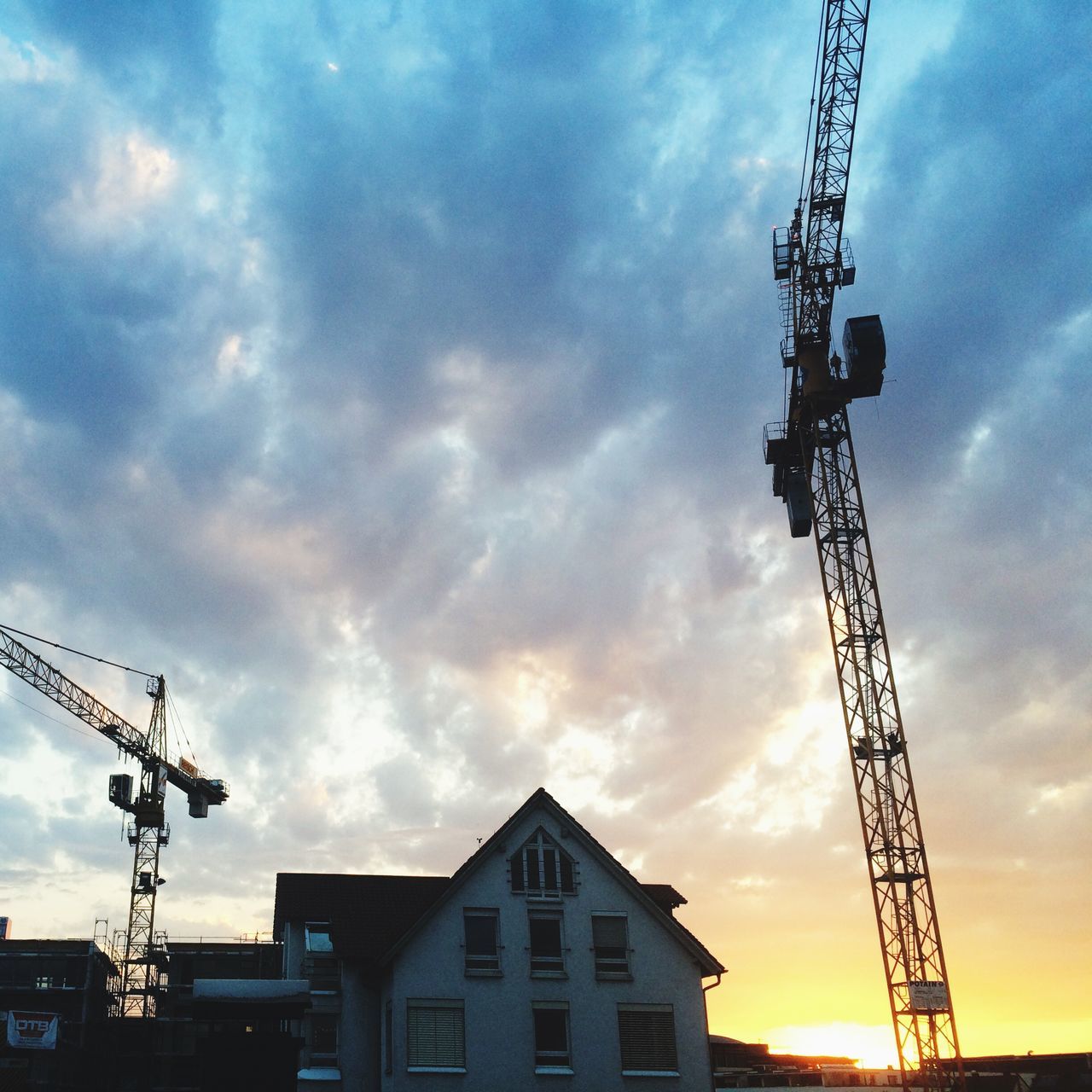 architecture, building exterior, built structure, sky, low angle view, cloud - sky, construction site, crane - construction machinery, sunset, cloudy, silhouette, development, crane, cloud, electricity pylon, industry, city, construction, power line, dusk