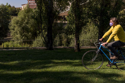 Man wearing face mask in the park with his bicycle