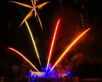 Low angle view of illuminated fireworks against sky at night