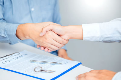 Midsection of woman holding hands on table