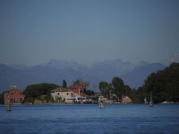 Scenic view of sea by buildings against clear sky