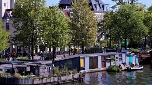 Bridge over canal amidst trees in city