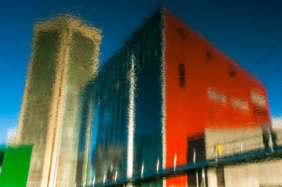 Low angle view of multi colored water against blue sky