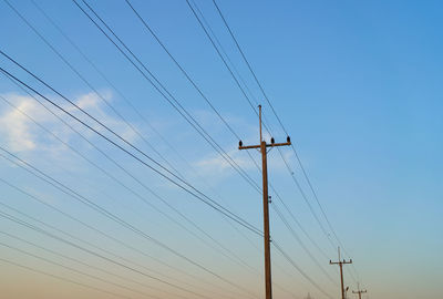 Low angle view of electricity pylon against clear sky