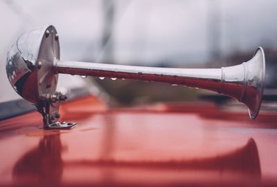 Close up of wet red vintage car horn