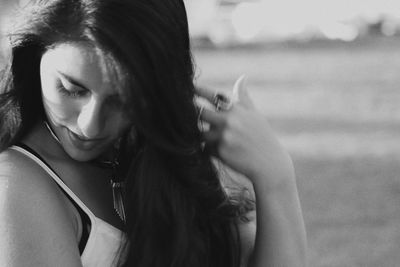 Close-up of smiling young woman with hand in hair