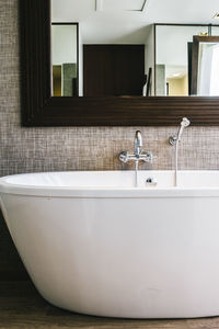 Porcelain wash bowl below mirror in bathroom