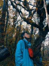 Man standing by trees in forest during autumn