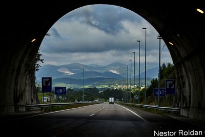 Road by mountains against sky