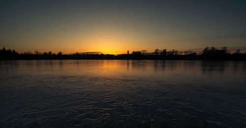 Scenic view of river against sky during sunset