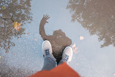 Low section of man standing on puddle