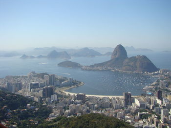 High angle view of city by sea against clear sky