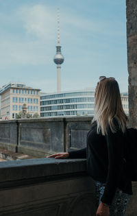 Rear view of woman against buildings in city