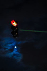 Low angle view of illuminated railway signal against sky at night
