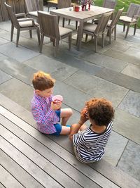 High angle view of mother and daughter sitting on table