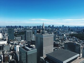 High angle view of city buildings against blue sky