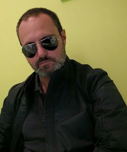 Portrait of man wearing sunglasses against gray background