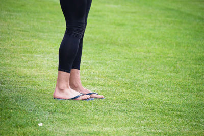 Low section of woman standing on field