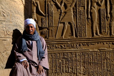 Man sitting against historic wall