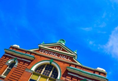 Low angle view of central hall against blue sky