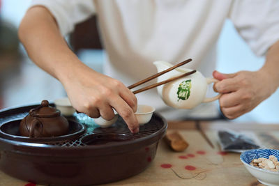 Close up of hands preparing tea in a traditional asian tea chamber