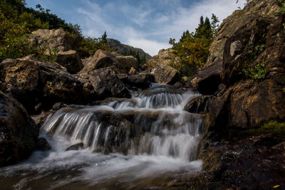 Low angle view of waterfall against sky