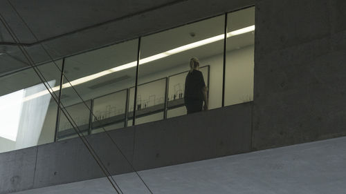 Silhouette person walking on illuminated wall of building