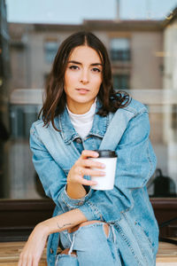 Portrait of young woman drinking coffee