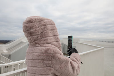 Man photographing against sky