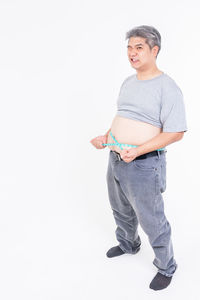 Portrait of young man standing against white background