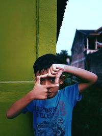 Portrait of boy standing against wall