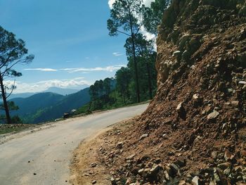 Scenic view of road by mountains against sky
